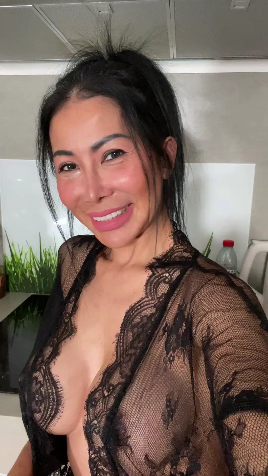 Angelinasexy frame at 00:00, The office becomes a runway as Angelinasexy’s sheer black lace robe teases her natural curves, pink lipstick smirking like a challenge