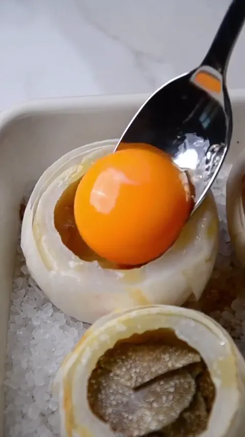 Delicious_Delilah frame at 00:36, Eggs sunnyside up—Delilah’s bald head reimagined as yolk halo