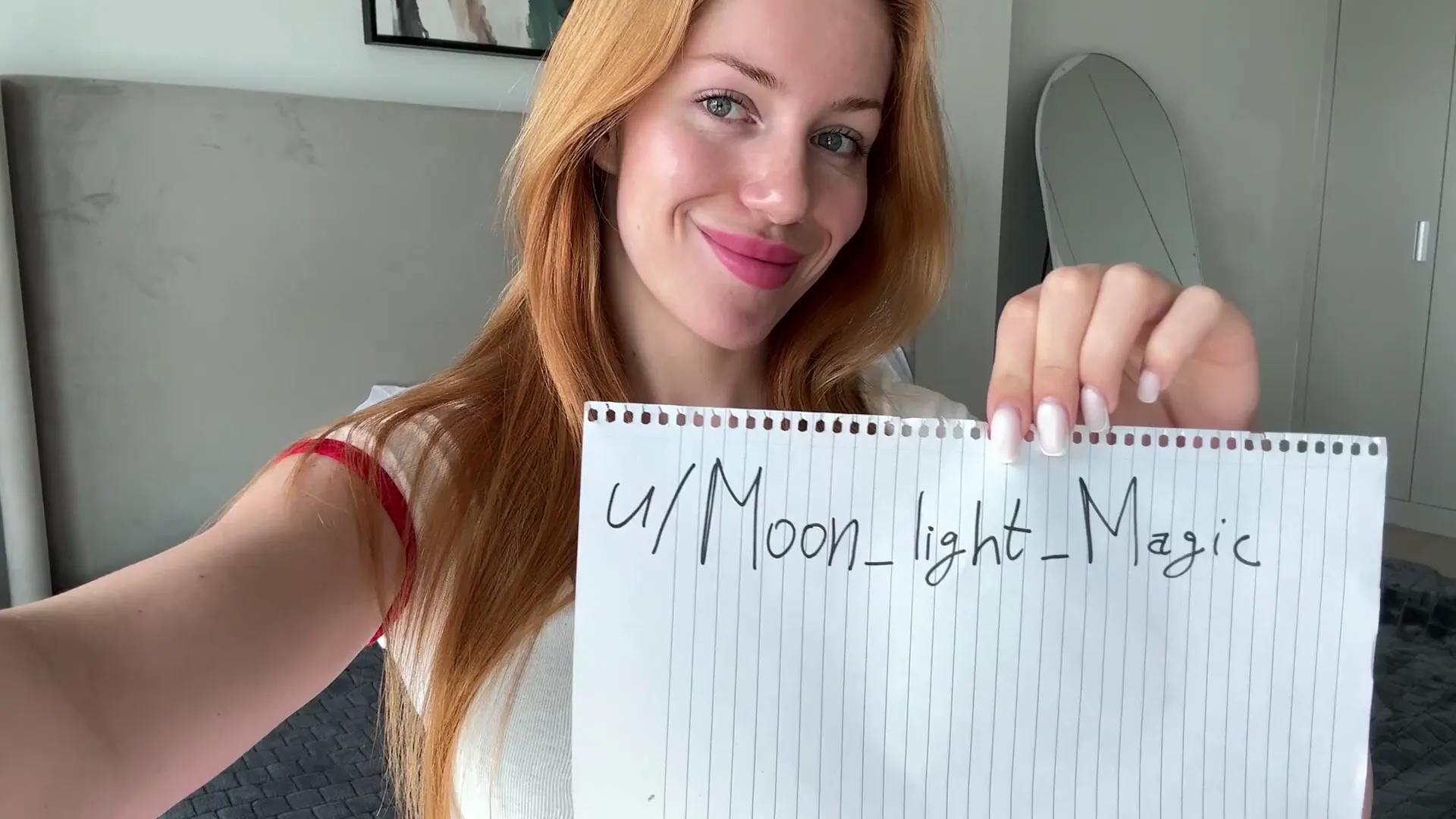 Moon_light_Magic frame at 00:04, Moon_light_Magic’s fiery crimson waves frame her porcelain glow as she flashes a mischievous grin, clutching a notepad branded with her NSFW alias