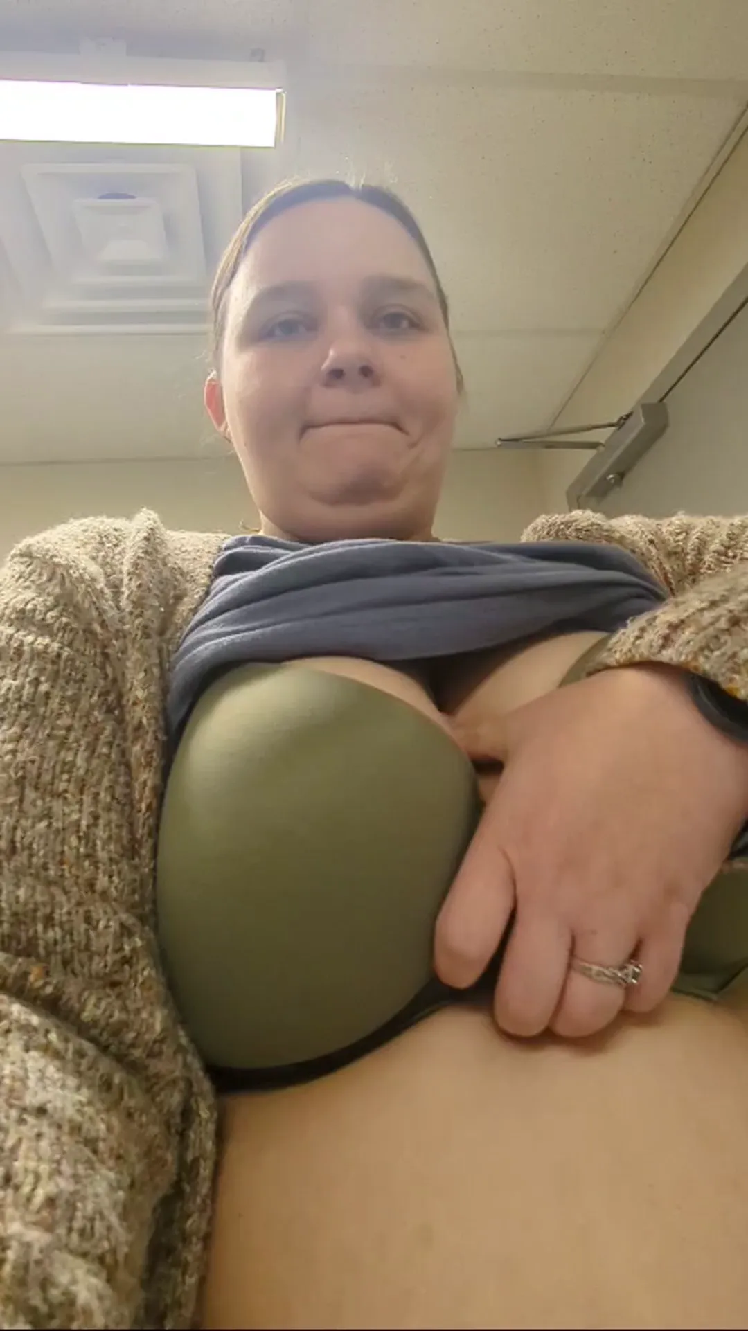 chubbycpl33 frame at 00:04, A textbook chubbycpl33 moment: Her smirk radiates 'casual rebellion' as she hoists a blue shirt and cardigan to showcase pale breasts spilling from an olive-green bra