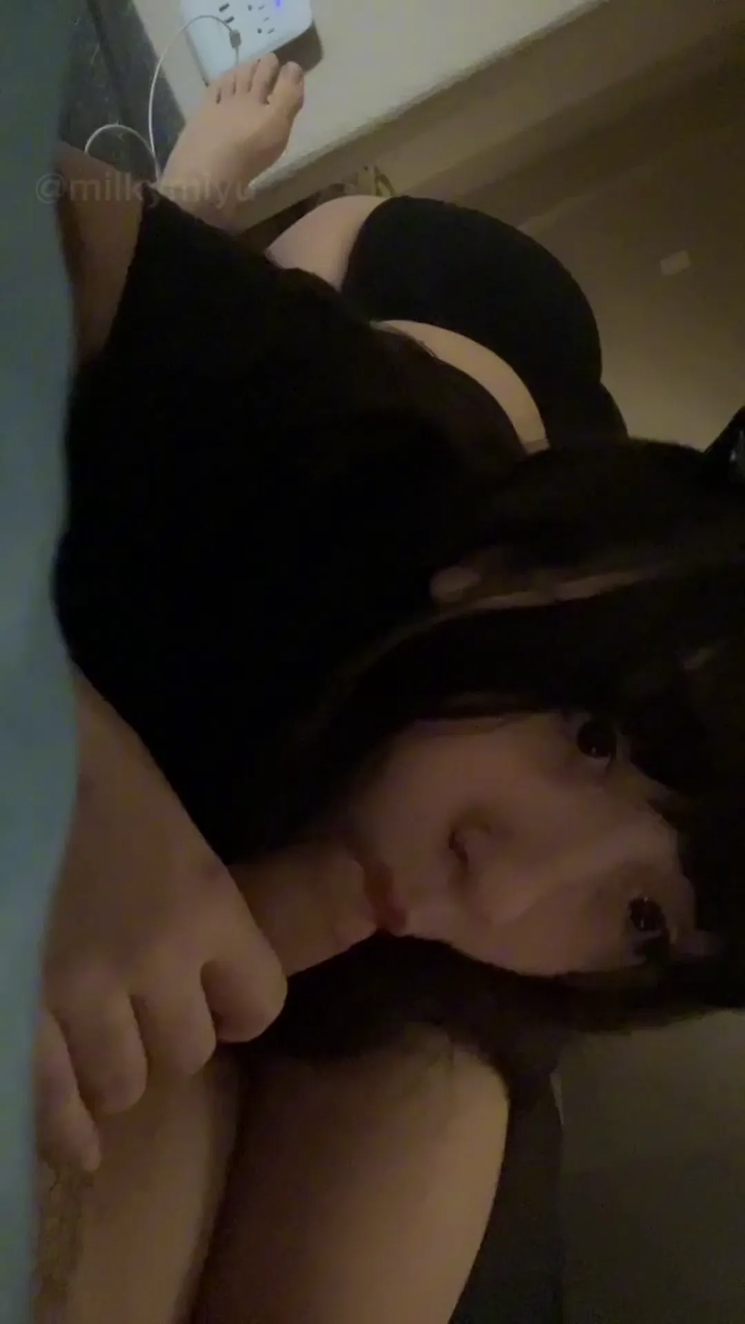 nymphetts frame at 00:19, MilkyMiyu’s porcelain skin glows like moonlight against her jet-black ensemble, her parted lips and unflinching eye contact radiating bedroom electricity