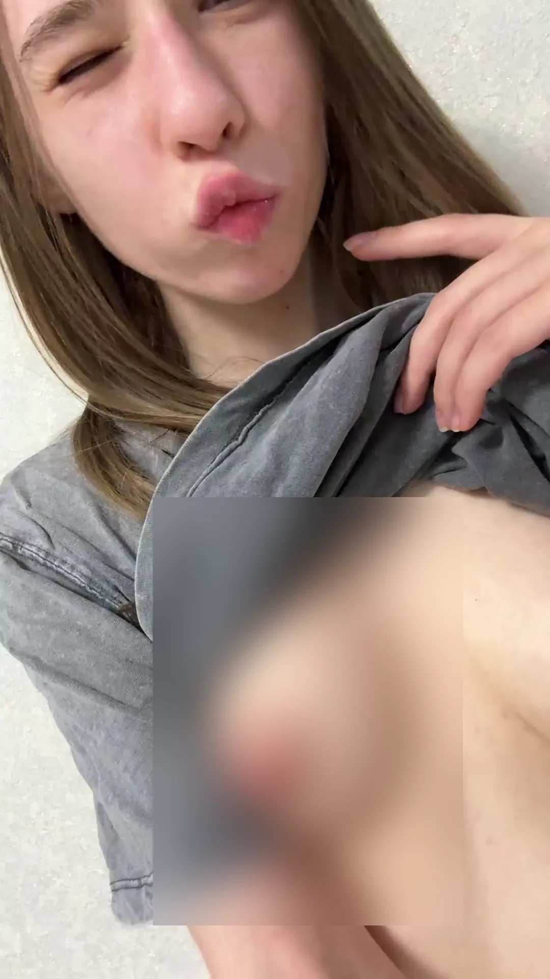 x_Rolly_Polly_x frame at 00:06, Hannah serves up a cheeky slice of girl-next-door rebellion here, her gray tee hiked to reveal a pert pink nipple—a stark contrast to her coy, lip-puckered smirk